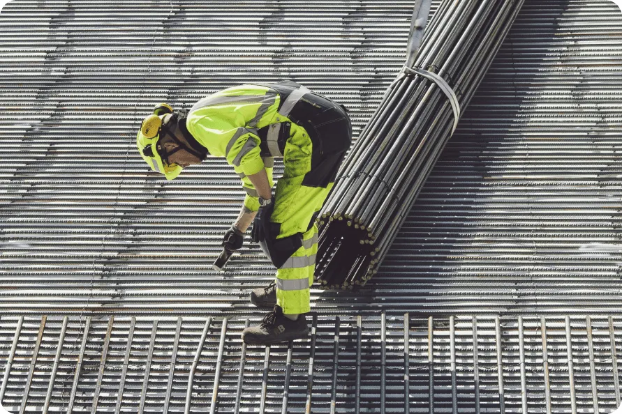 A construction worker working on a metal grating.